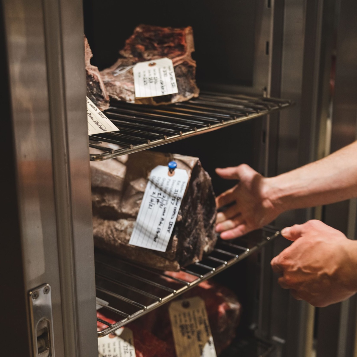 Chef selecting premium steak cut in the steakhouse kitchen.