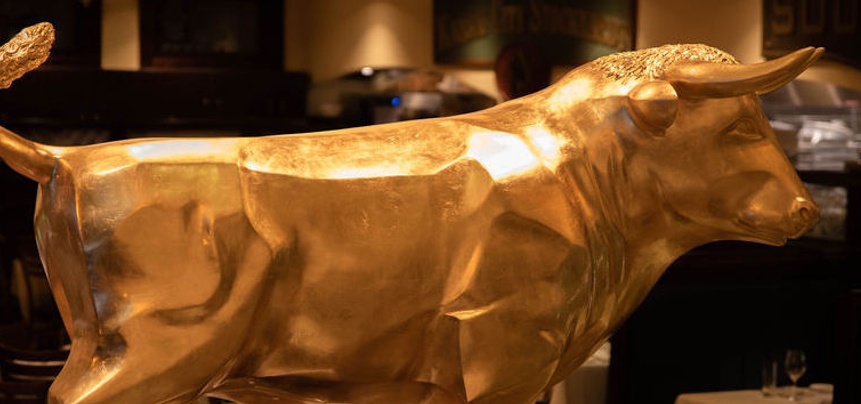 Golden bull statue greeting guests at Minneapolis steakhouse.