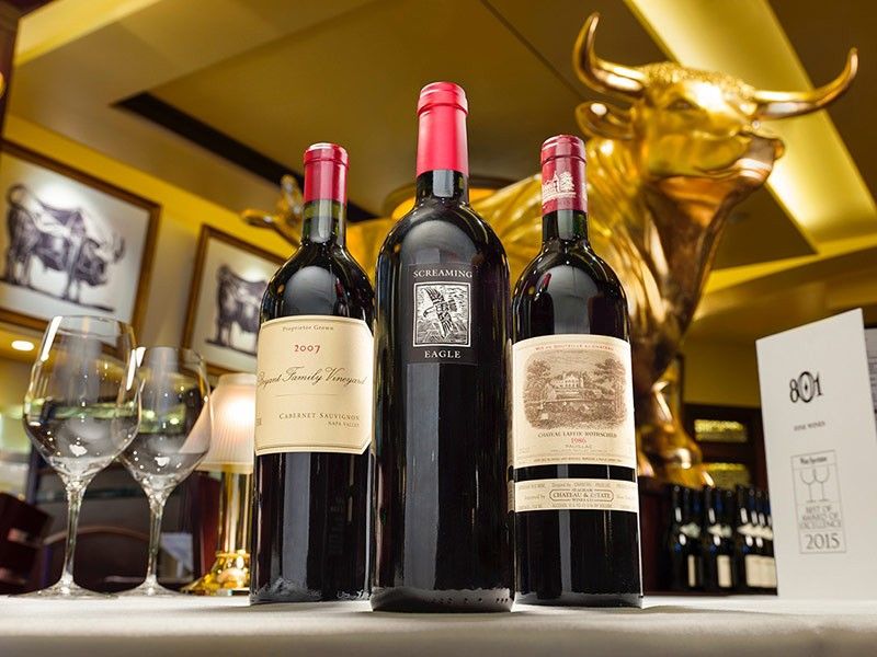 Wine bottles and glasses with gold bull statue at 801 Chop House Denver, CO