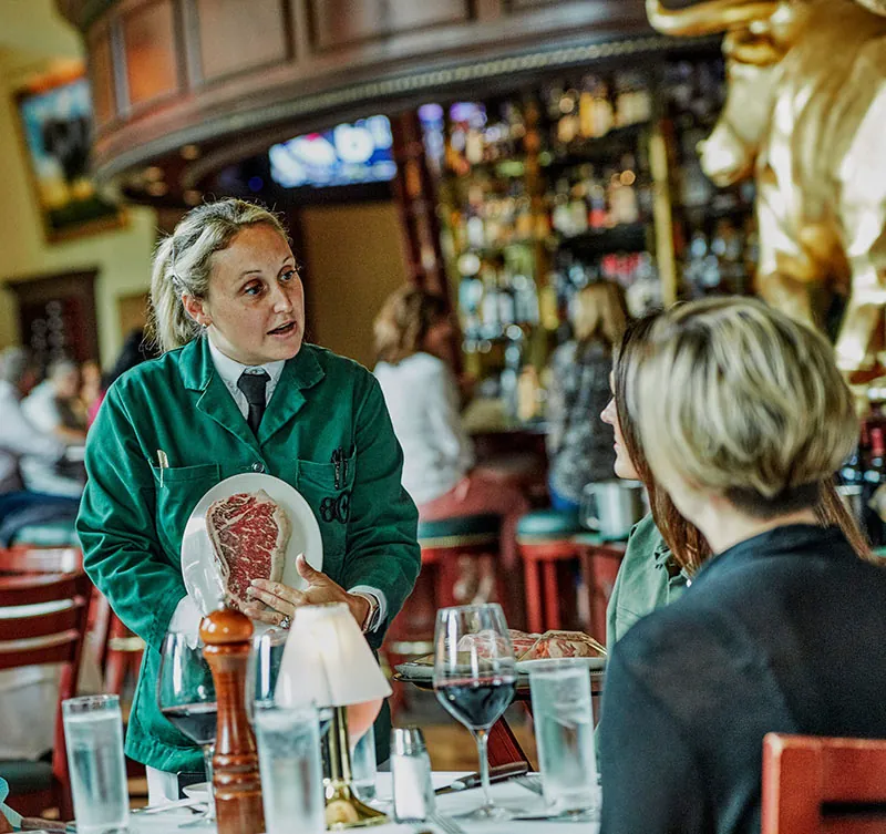 Server displaying a cut of meat