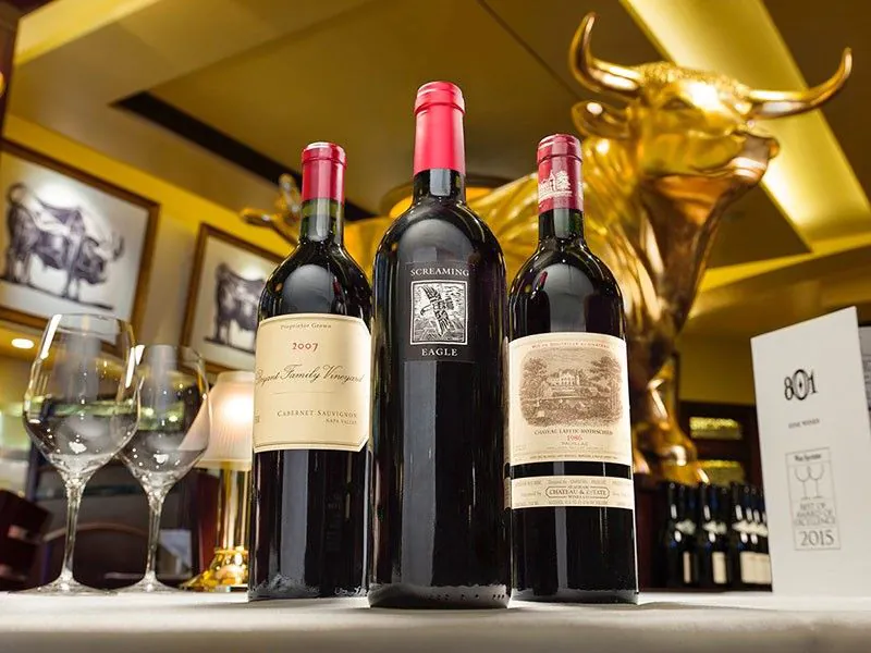 Wine bottles and glasses with gold bull statue at 801 Chop House Denver, CO